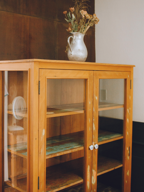 ein alter Vitrinenschrank mit abgenutzter Holzoberfläche