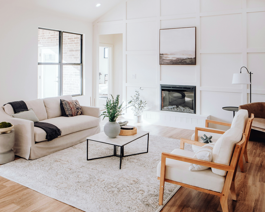 Wohnzimmer mit hochweißen Wänden, Sofa, Beistelltisch und Sesseln