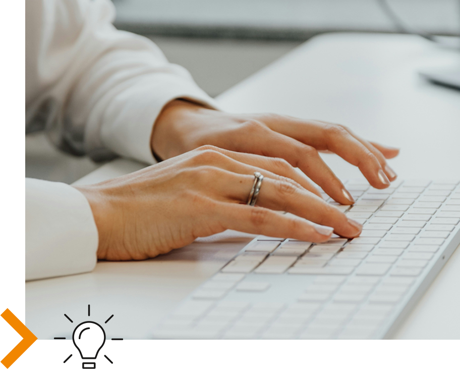Foto von Händen auf einer Tastatur, davor ein Glühbirnen-Icon