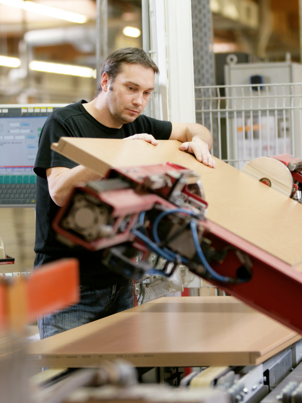 Ein Mann prüft eine Tür in der Qualitätssicherung.