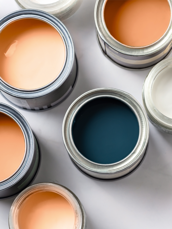 Farbeimer mit Lacken in Orange, Dunkelblau und Weiß